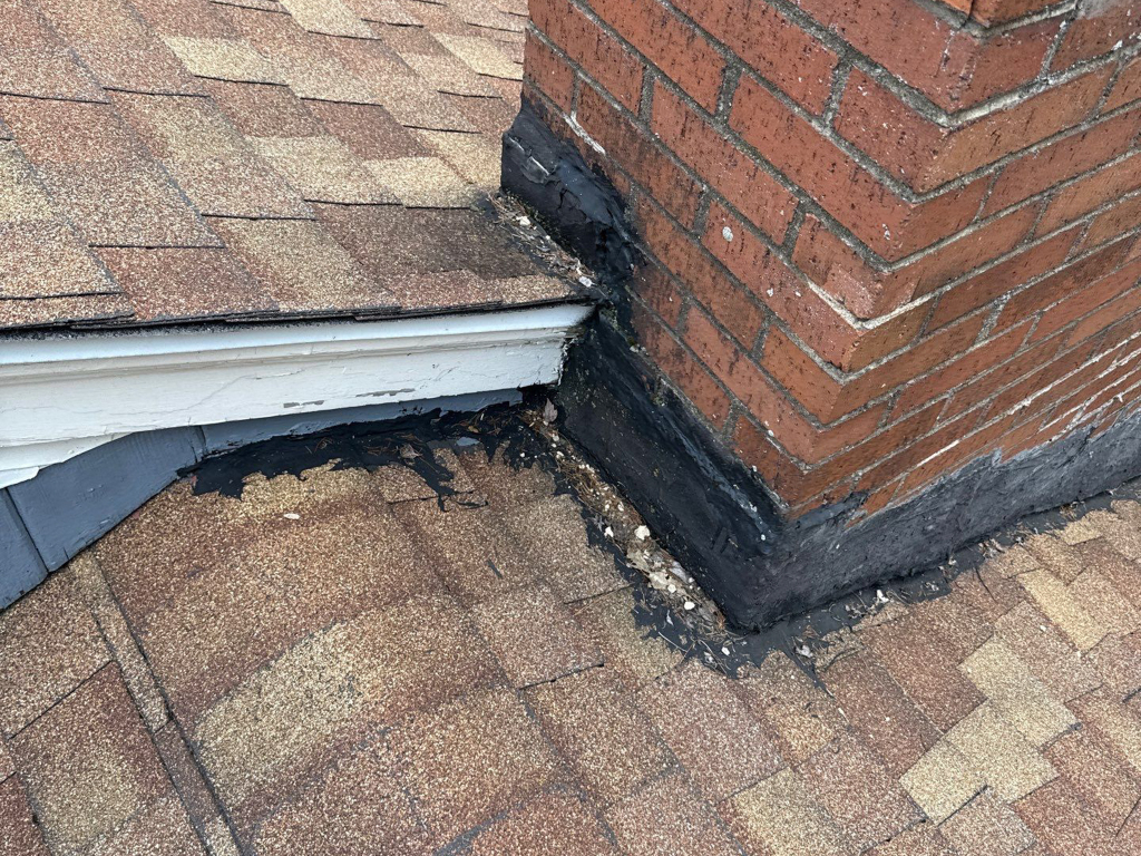 Photo of damaged chimney caulking causing a roof leak.