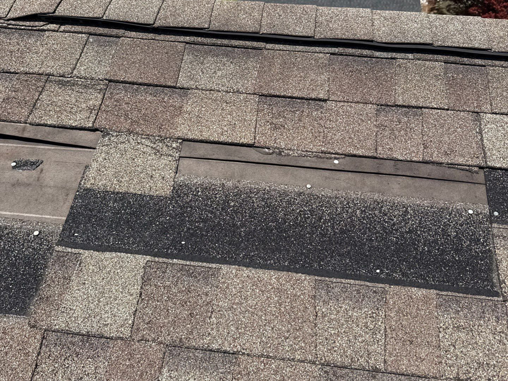 Wind damaged roof showcasing missing shingles. Captured during a roof inspection in Ohio.