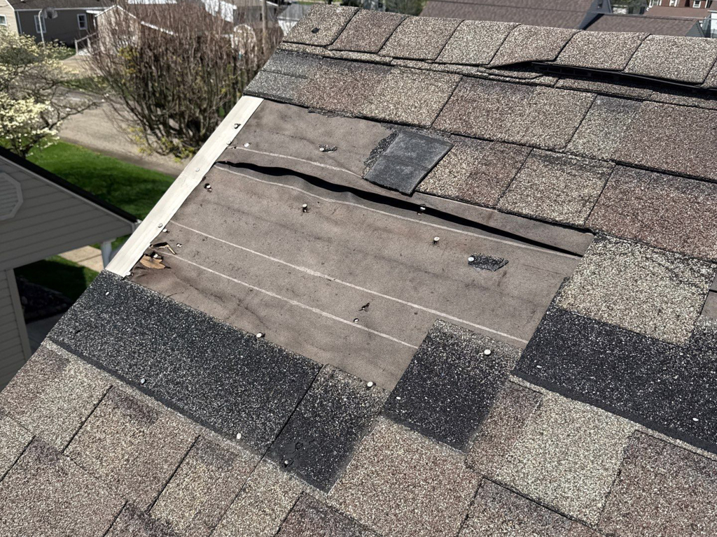 Roof inspection photo showcasing wind damage and missing shingles on an Ohio homeowners roof.